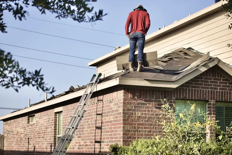 Professional roofer working on a residential roof in Elmville